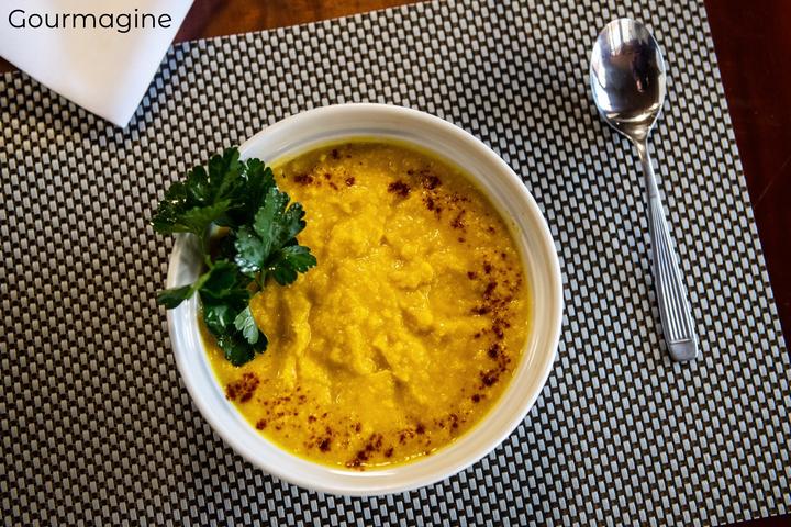 Argentinian pumpkin corn puree Humita in a white bowl next to a spoon