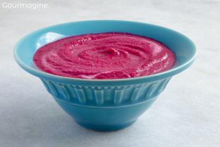 A blue-green bowl filled with beetroot cream soup