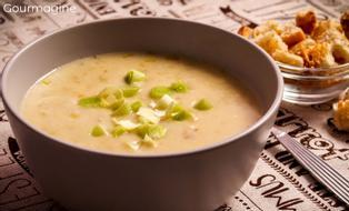 A dark brown bowl filled with potato leek soup