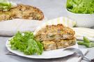 Zwei Stücke Poulet-Lauch-Wähen angerichtet auf einem weissen Teller mit grünen Salatblättern