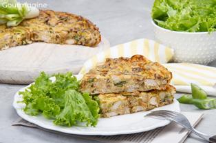 Two pieces of chicken leek pie on a white plate with green salad leaves