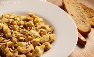 Pouletstücke mit Lauch und Sonnenblumenkerne angerichtet auf einem weissen Teller
