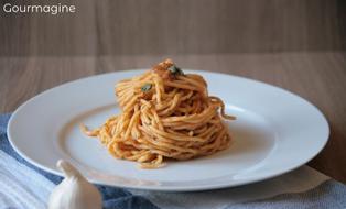 Spaghetti with pesto served on a white plate