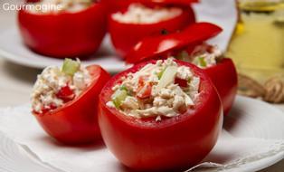 Drei Tomaten gefüllt mit einer Poulet-Peperoni-Joghurt-Mischung und angerichtet auf einem weissen Teller