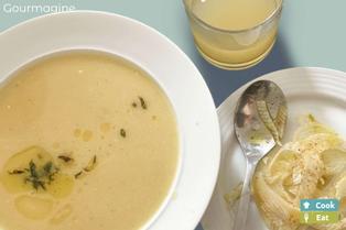 Weisser Suppenteller gefüllt mit Apfel-Fenchel-Suppe neben einem kleinen Teller mit Fenchel-Streifen