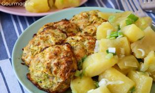 Several zucchini balls and potato pieces arranged on a green plate
